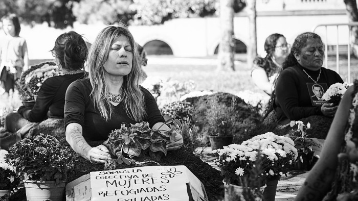 Women around flowers and banners with vindictive inscriptions.