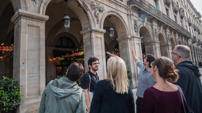 People observing a set of arches in the city of Barcelona.