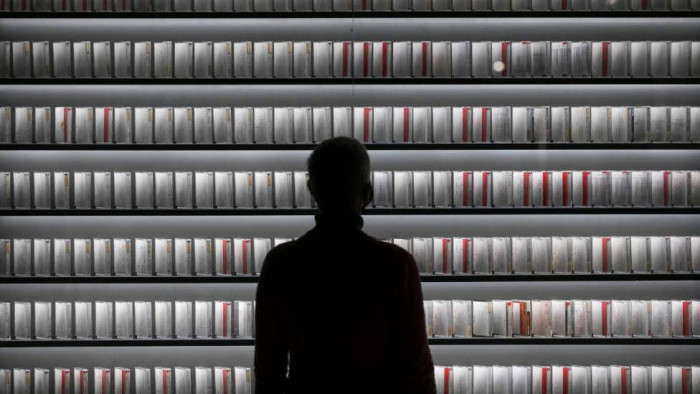 Person looking at a bookshelf full of lab results.