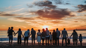 People of all ages on the beach watching a sunset