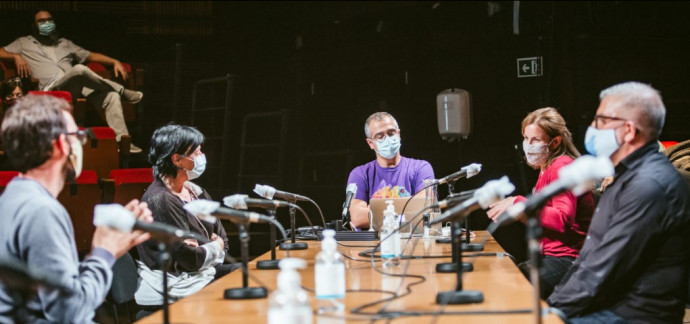 Persones debatent al voltant d'una taula.